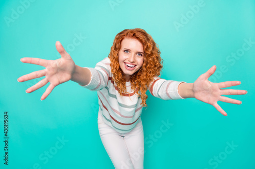 Photo portrait curly woman smiling keeping hands forward missing friend isolated vivid turquoise color background © deagreez