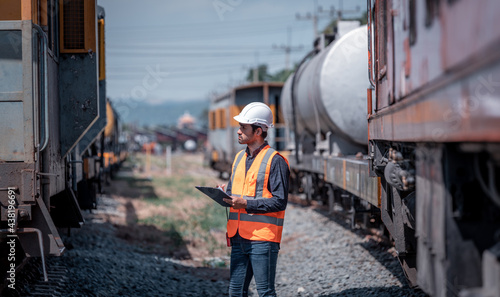 Engineer railway under checking construction process train testing and checking railway work on railroad station with radio communication .Engineer wearing safety uniform and safety helmet in work.