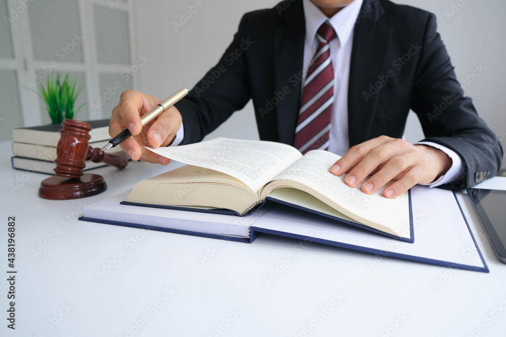 Justice and law concept. Gavel on sounding block in hand's Male judge at a courtroom, working with document law books, report the case on table in modern office. Justice and law concept. Gavel on sounding block in hand's Male judge at a courtroom, working with document law books, report the case on table in modern office.