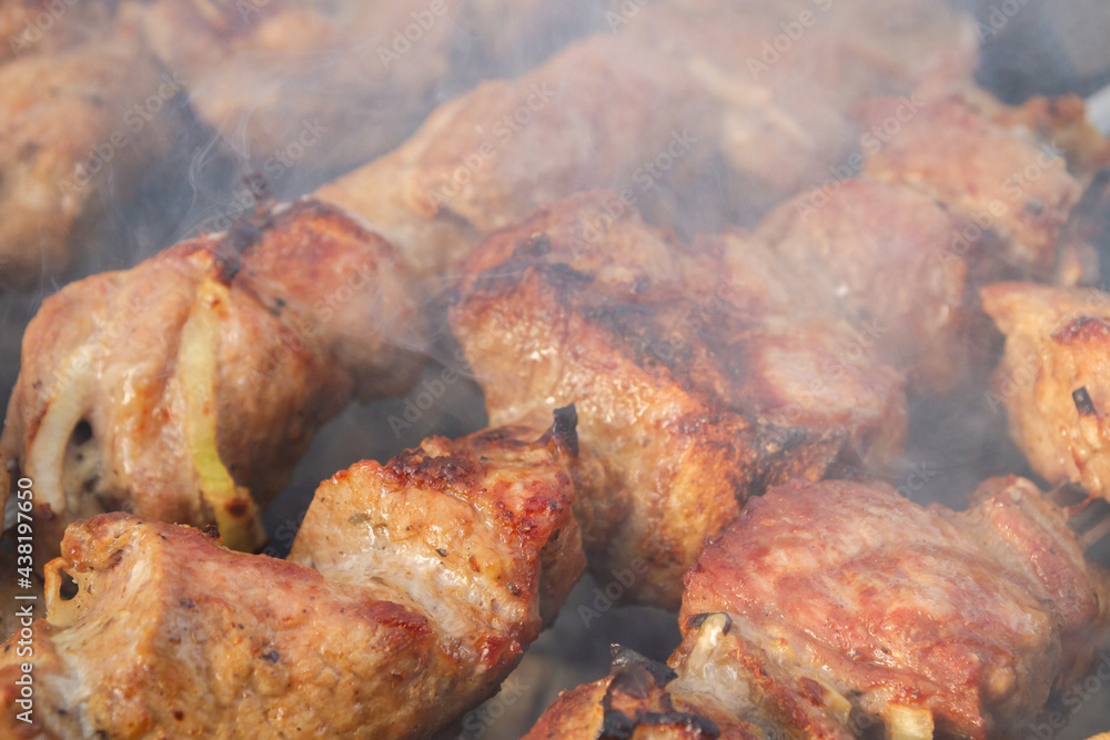 Shish Kebab made from pieces of pork is cooked on skewers on the grill Shish Kebab made from pieces of pork is cooked on skewers on the grill