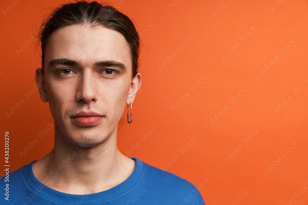 Young white man with earring posing and looking at camera Young white man with earring posing and looking at camera