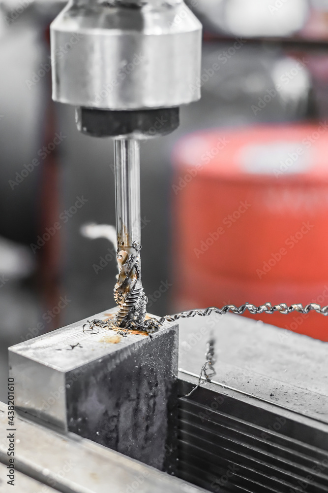 A tap on a machine for tapping a hole in a part. A tap on a machine for tapping a hole in a part.