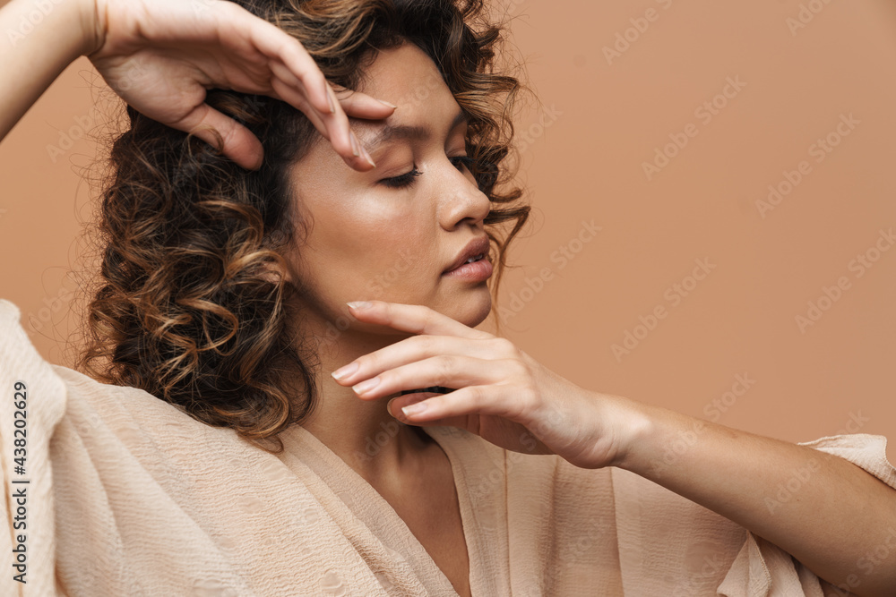 Fototapeta premium Young curly hispanic woman posing and gesturing on camera