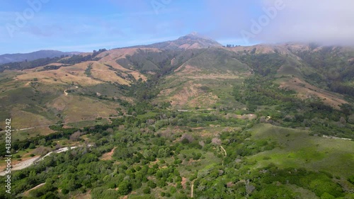 Aerial video of oceanside cliffs along the California coast mountains. 
