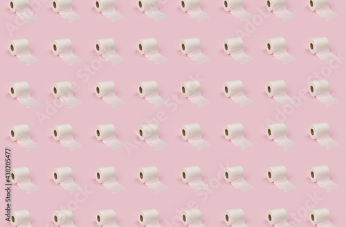 Rolls of white toilet paper on pink background.