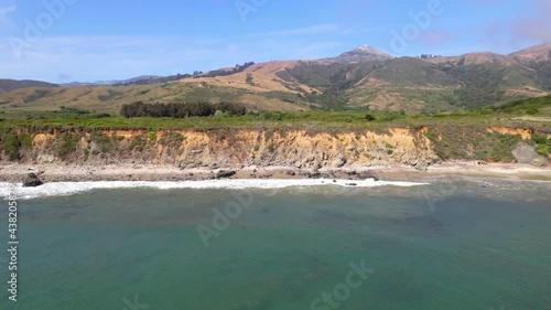 Aerial video of oceanside cliffs along the California coast mountains. 