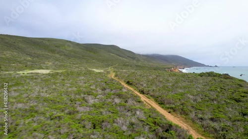 Aerial video of oceanside cliffs along the California coast mountains. 