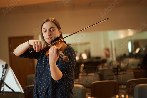 Female violinist performing classical music in hall