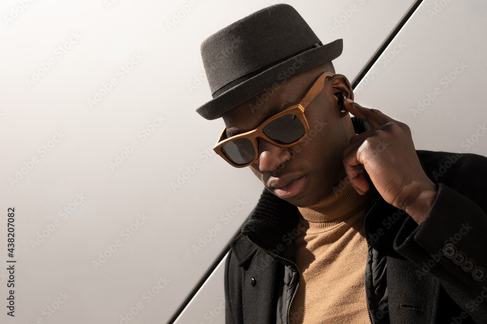 Stylish black man standing against white wall Stylish black man standing against white wall