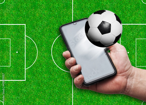 holding a smartphone with football  following soccer FIFA world cup on mobile