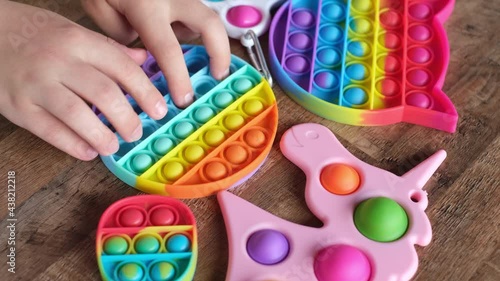 New popular silicone popit toy, baby is playing with it. Rainbow Trendy Pop it fidget toy