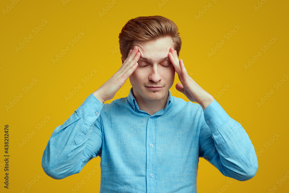 Man with suffers from migraine keeps fingers on temples to reveal pain Man with suffers from migraine keeps fingers on temples to reveal pain