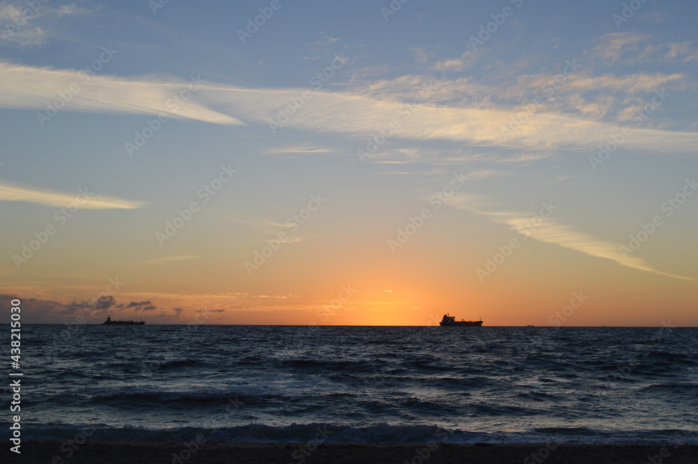 Beautiful Sunrise on Fort Lauderdale Beach, Florida, USA with fishing boat far away