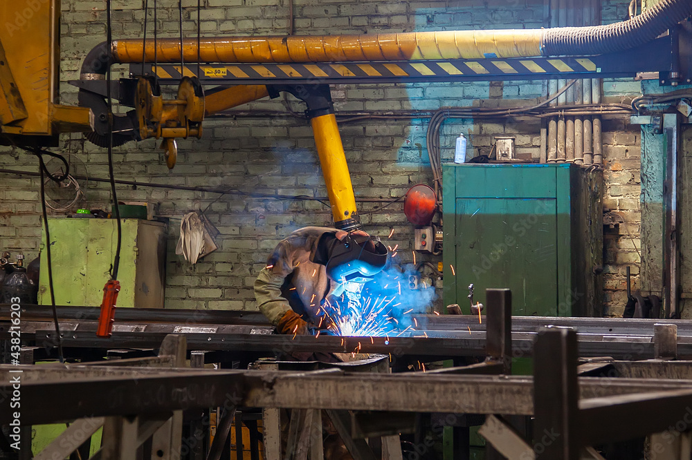 Welder at work in a factory. Industrial worker welding steel. Welding metal in the workshop with sparks Welder at work in a factory. Industrial worker welding steel. Welding metal in the workshop with sparks