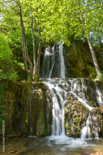 Beautiful waterfall in green forest in jungle. Jungle landscape with flowing red water of waterfall at deep tropical rain forest. National Park Old Mountain, Serbia