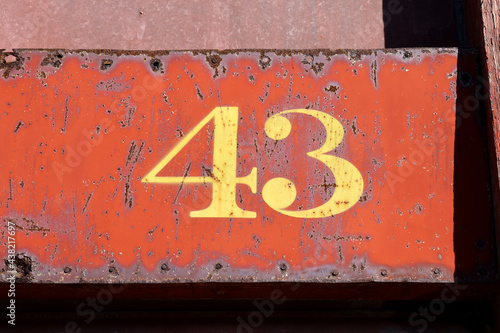 Close Up of Yellow Number 43 Painted on Rusty Steel Basckground