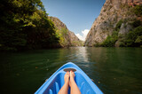 Kayaking through river in Matka canyon, Macedonia. Woman legs in the blue kayak