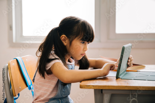 Canvas Print Asian school girl using digital device in school classroom, digital native, technology, learning, touchscreen