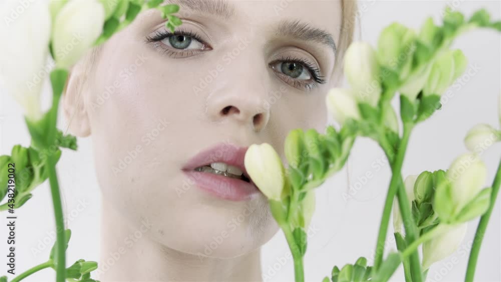 oung woman with fresh exotic white flowers. Skin care. Body care. Natural and organic cosmetics. Care cosmetics. Close up of a woman's face. White flowers, green stems. Natural makeup. oung woman with fresh exotic white flowers. Skin care. Body care. Natural and organic cosmetics. Care cosmetics. Close up of a woman's face. White flowers, green stems. Natural makeup.