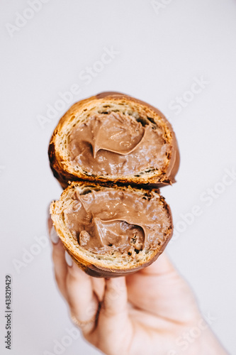 hand holding a croissant with chocolate 