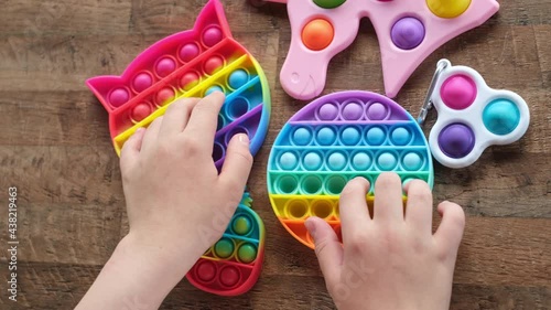 New popular silicone popit toy, baby is playing with it. Rainbow Trendy Pop it fidget toy