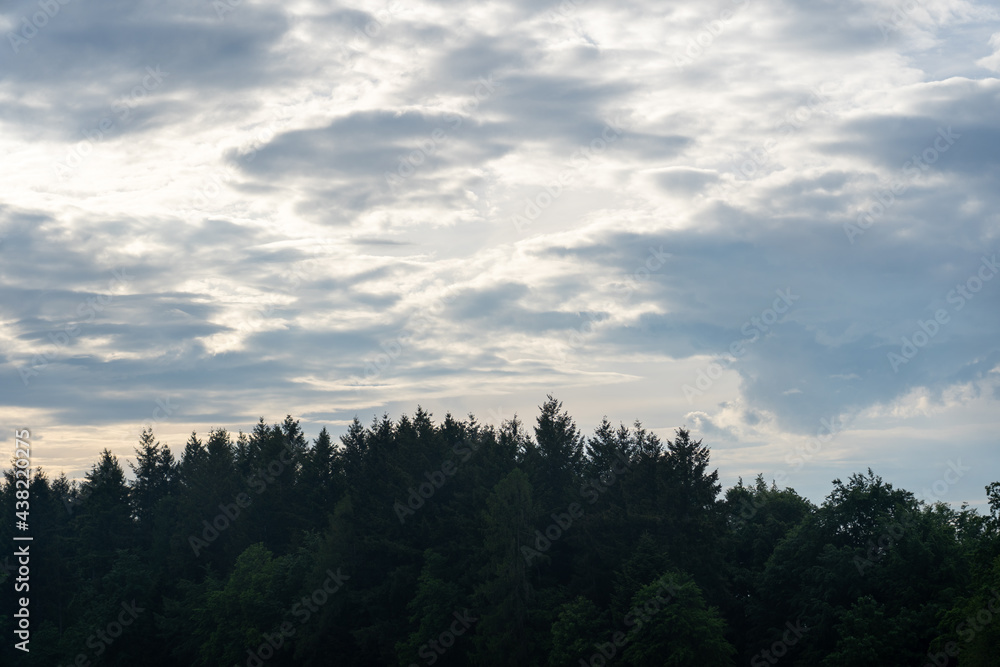 Wolken über einem Hügel mit Wald Wolken über einem Hügel mit Wald