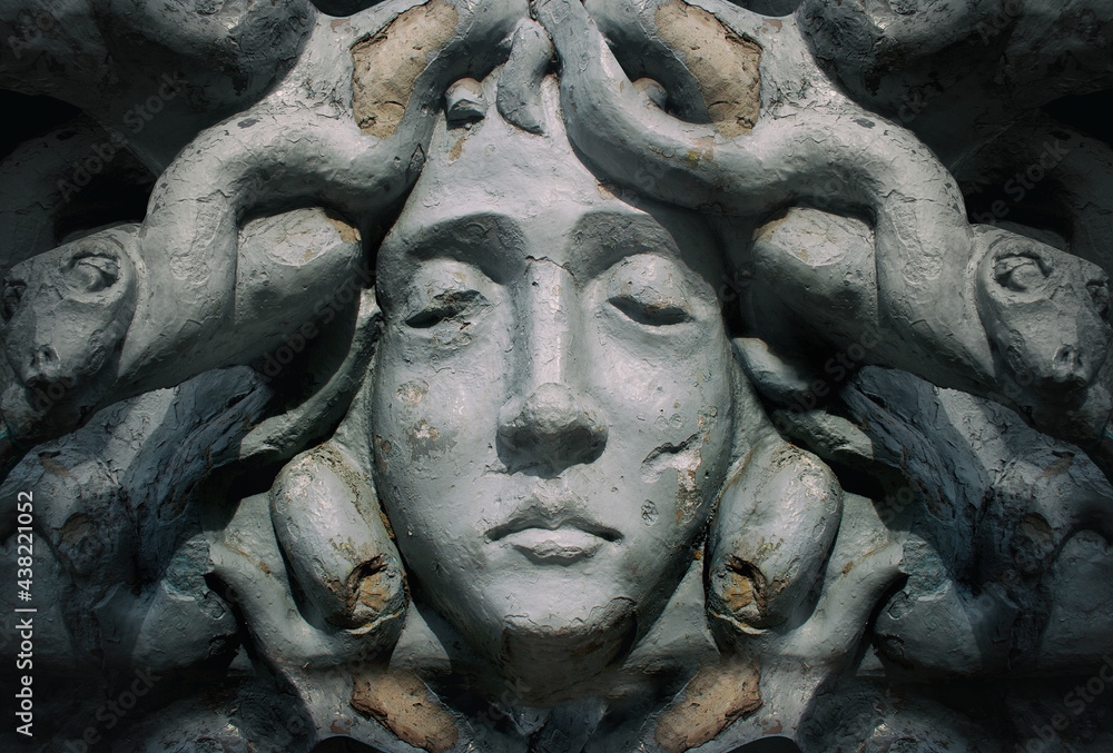 Medusa goddess cracked stone face statue.