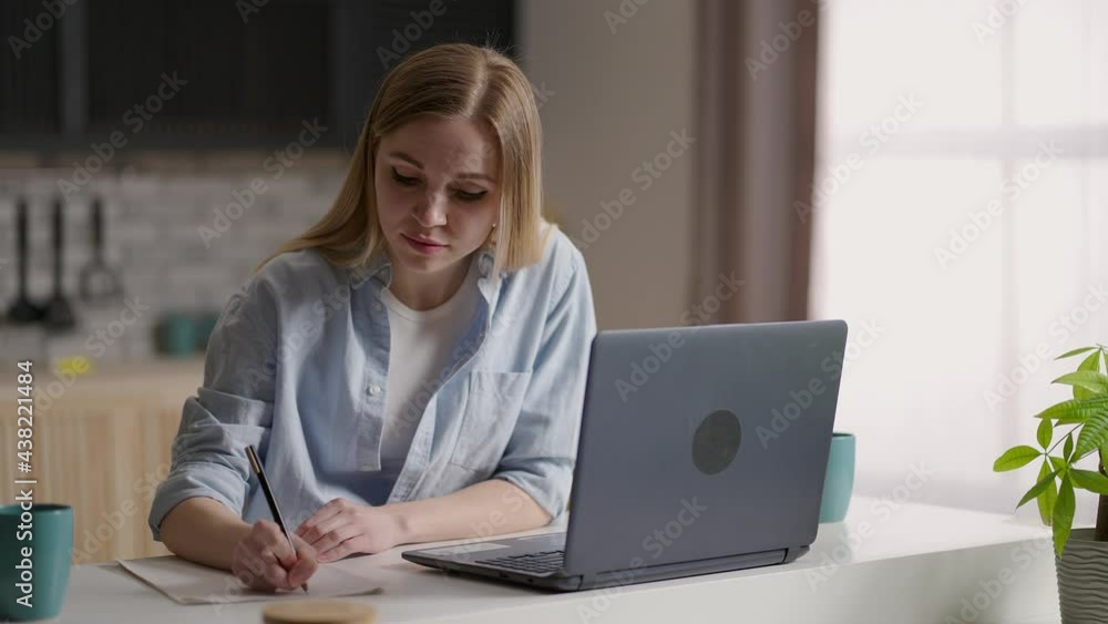 serious female student wear elearning study with online tutor teacher talk conference calling do video chat learn language make notes sit at home office desk look at laptop computer serious female student wear elearning study with online tutor teacher talk conference calling do video chat learn language make notes sit at home office desk look at laptop computer