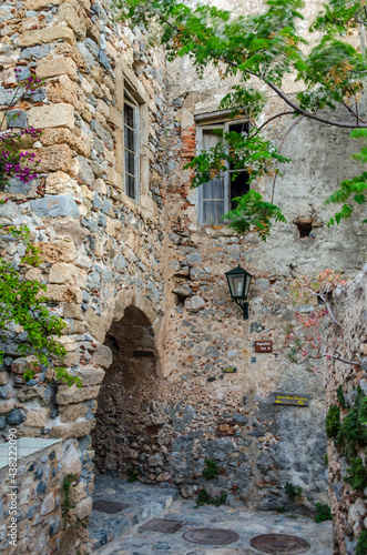Byzantine Street with Traditional Alley with Arch in Monemvasia Island, Peloponnese, Greece. Medieval Style Stone House with Big Windows Above the Footpath.
