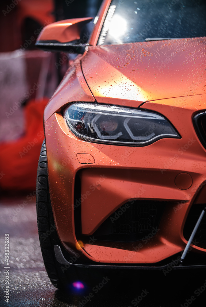 BMW M3 F80 Sport Car wrapped in orange vinyl wrap, equipped with custom  wide body kit and carbon fiber parts and modern laser led headlights on  Drift And Cars Show Stock-Foto