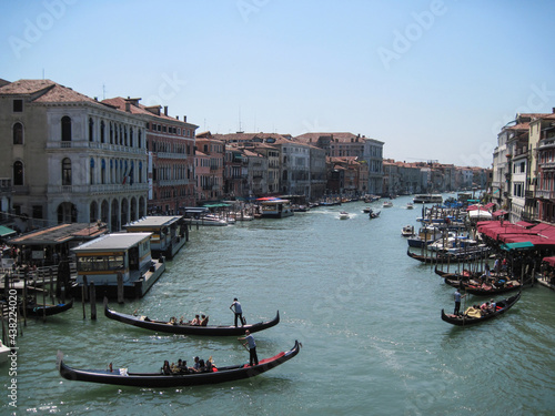 Romantic Venetian landscape. Tourists in a gondola on a walk along a Grand Canal in the old town. Famous historical heritage city.