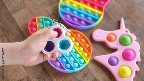 New popular silicone popit toy, baby is playing with it. Rainbow Trendy Pop it fidget toy