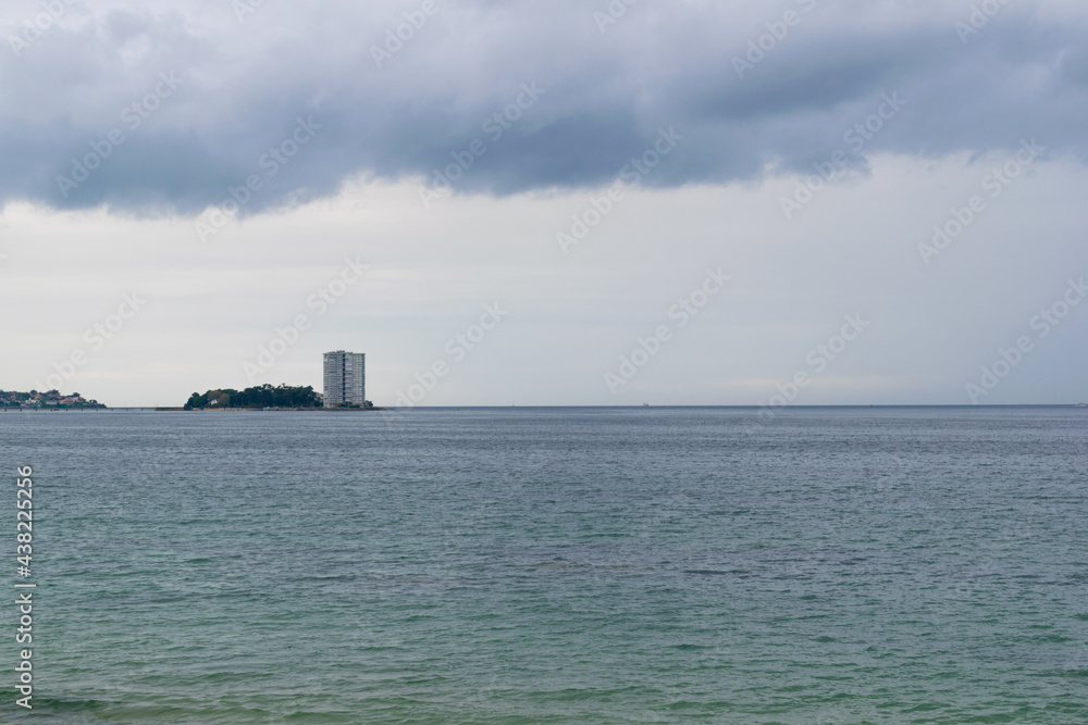 View of the island of Toralla during the day with a stormy sky. Vigo
