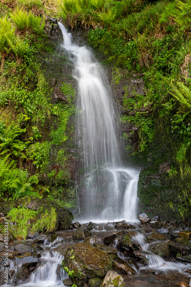 Fototapeta premium Long exposure of the Hollowbrook waterfall on the South West Coastpath from Woody Bay to Heddons Mouth in Devon