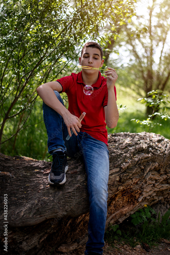 Teenager boy with soap bubbles in the park Teenager boy with soap bubbles in the park