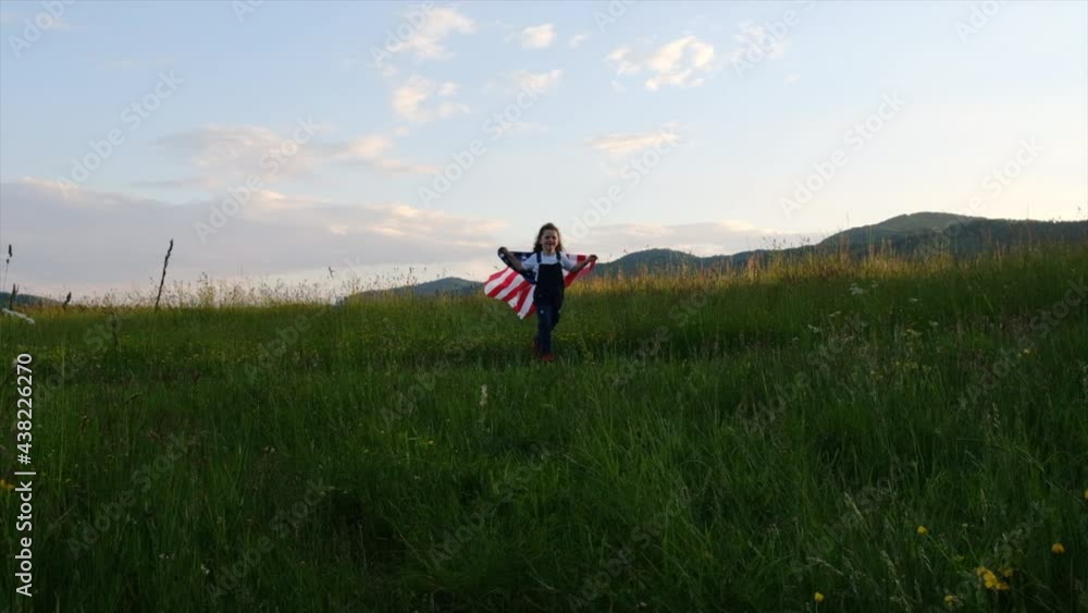 Happy small daughter holds national USA flag running to smiling mother and jumping into her embrace on background mountains during summer sunset. American flag, country, patriotism, independence day Happy small daughter holds national USA flag running to smiling mother and jumping into her embrace on background mountains during summer sunset. American flag, country, patriotism, independence day