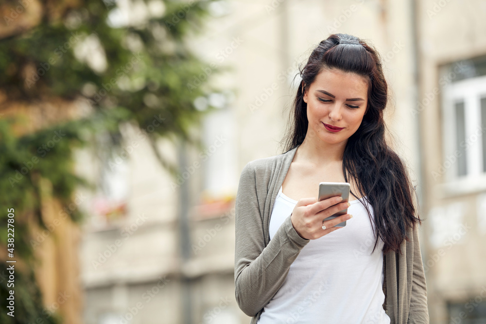 Young cute female using smartphone on the street. Young cute female using smartphone on the street.