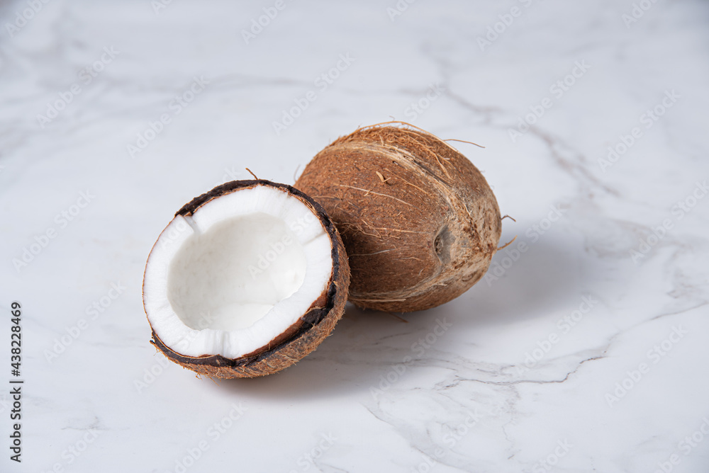 fresh coconut on white marble background. Healthy and vegan food. Copy space