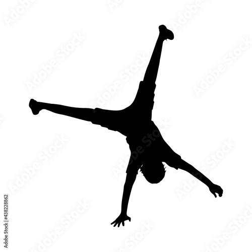 Silhouette boy standing on his one hand handstand.