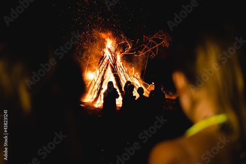Huge bonfire with people around it at night