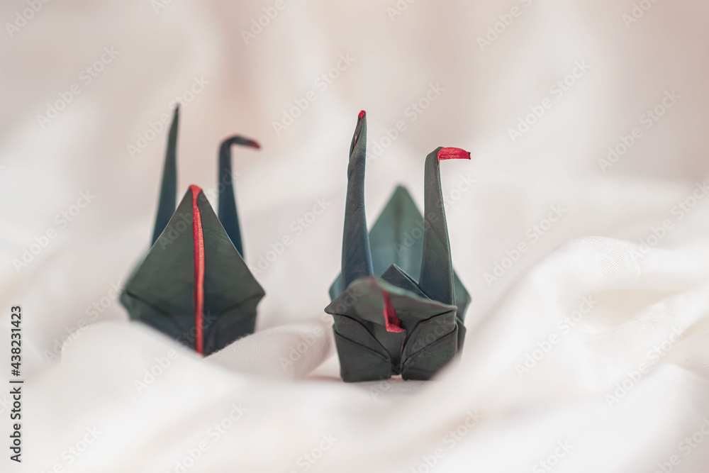 Fototapeta premium Couple of origami paper cranes close-up on light background