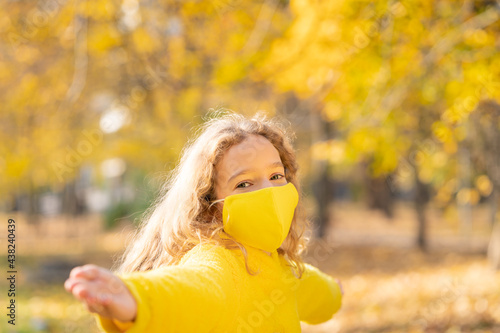 Happy child wearing protective mask in autumn park