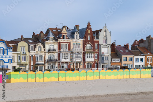 Colorful beach huts in front of historic seaside buildings
