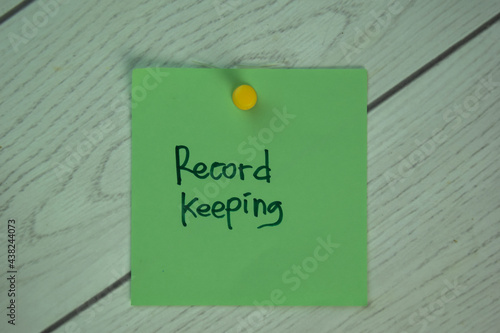 Record Keeping write on sticky notes isolated on Wooden Table.