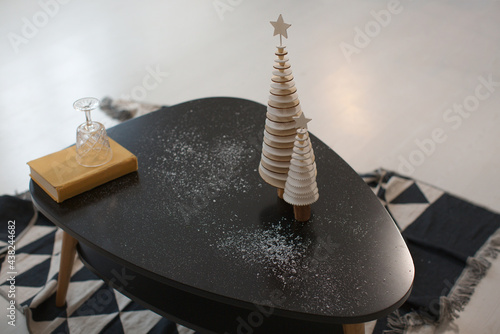 Black coffee table and decorative Christmas trees made of wood
