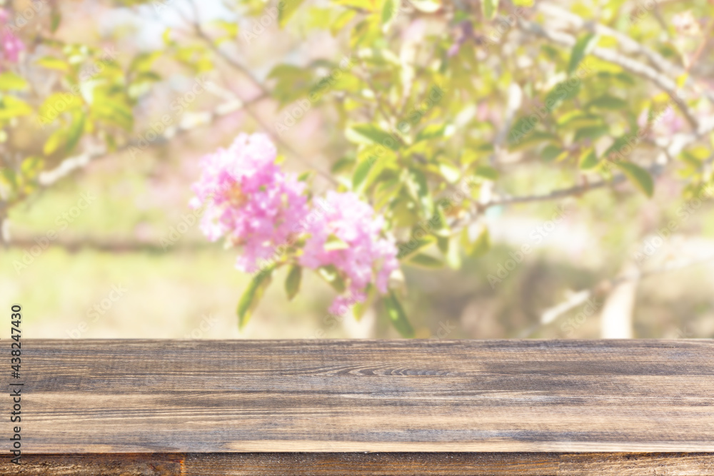 wood table top on blur trees with pink flowers background wood table top on blur trees with pink flowers background