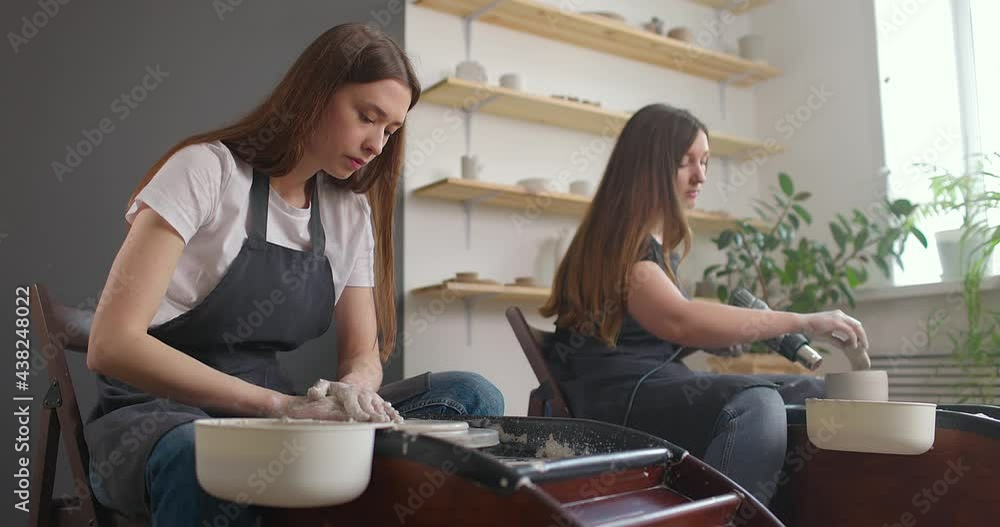 Pottery studio concept. Two young woman using pottery wheel, handmade ceramics, creative. Slow motion Pottery studio concept. Two young woman using pottery wheel, handmade ceramics, creative. Slow motion