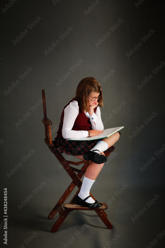 Girl child schoolgirl in a school uniform in the studio, classic school photos, dark background Girl child schoolgirl in a school uniform in the studio, classic school photos, dark background