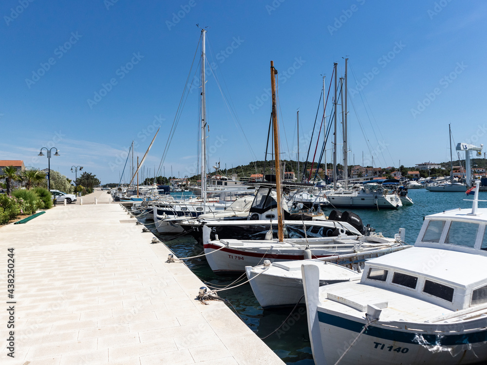 Fototapeta premium Jezera, Croatia-June 3rd, 2021: Anchored fishing boats in the port of small fishing village Jezera, located on Murter island, Croatia at the start of summer season