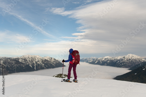 Person snowshoeing in the mountains above the clouds 